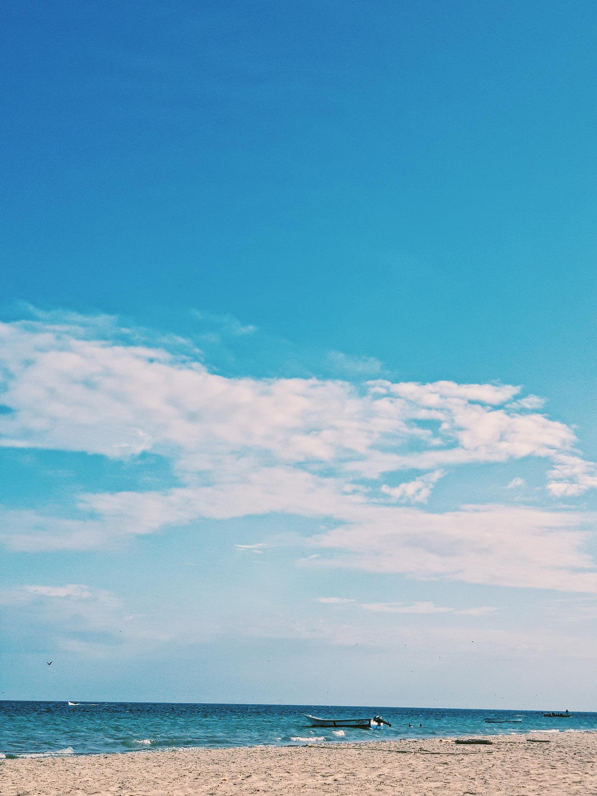 Peaceful beach scene in Punta Arenas, Venezuela with blue skies and serene ocean view.